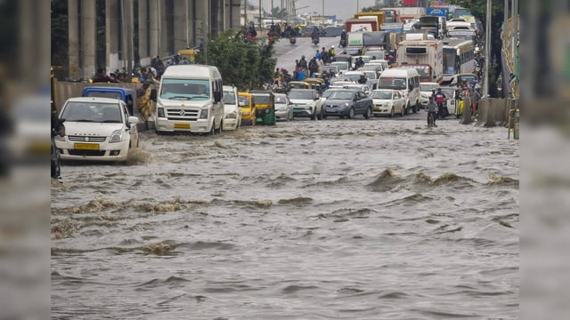 Bengaluru: Vehicles move through a waterlogged road after heavy rains, in Bengal...