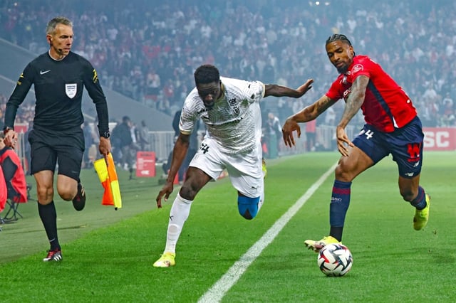 Le milieu ivoirien de Reims Mory Gbane (au centre) à la lutte avec le Lillois Alexsandro le 17 mai 2025 au stade Pierre-Mauroy