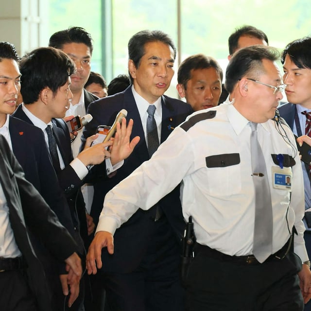 Japans Agrarminister Taku Eto (Mitte) umringt von Reportern kurz bevor er seinen Rücktritt einreicht.