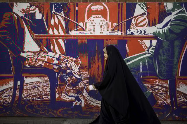 Iranians pass by the anti-American murals painted on the walls of the former embassy of the United States of America in Tehran, Iran on April 16, 2025.