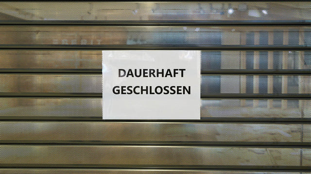 "Dauerhaft geschlossen"-Schild vor einem leeren Laden.