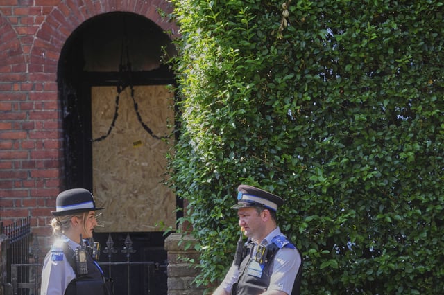 Police Community Support Officers stand near the fire damaged  doorway of a house belonging to British Prime Minister Keir Starmer in Kentish Town in London, Tuesday, May 13, 2025. 