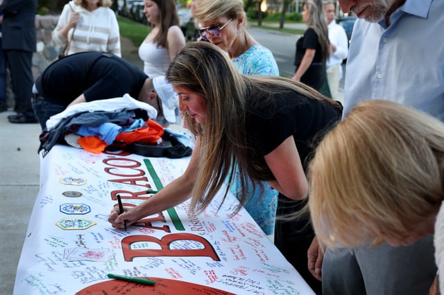 People sign on a banner while arriving at St. Barnabas Church on June 26, 2024, before a prayer vigil for Nick Barraco who was seriously injured at his restaurant in Chicago’s Mount Greenwood. (Chris Sweda/Chicago Tribune)