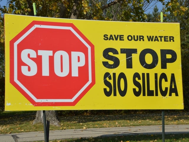 A sign in opposition to a proposed silica sand mine is seen on the side of a highway in the RM of Springfield.