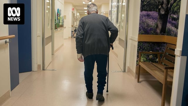 An elderly man walks down the corridor of a secure ward in Sunshine Hospital.