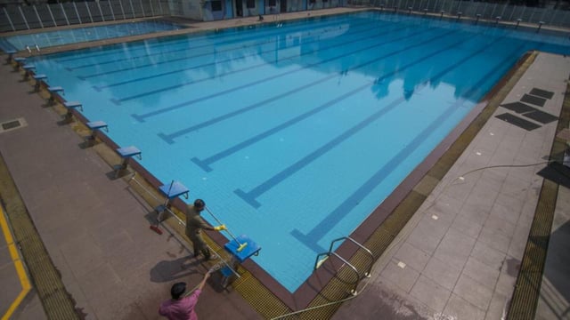 Mumbai, India - November 05, 2020: Workers are seen cleaning up the swimming pool to make it ready to reopen after government has given permission to reopen the swimming pool after being shut for nearly 6-7 months due to Covid-19 pandemic at A.K. Vaidya Swimming Pool, Chembur in Mumbai, India, on Thursday, November 5, 2020. (Photo by Pratik Chorge/Hindustan Times) (Pratik Chorge/HT PHOTO)
