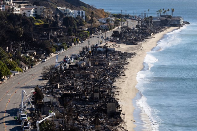 LOS ANGELES, CALIFORNIA – JANUARY 12: Vehicles run on the Palisades section of Pacific Coast Highway along scorched structures and trees by wildfires on January 12, 2025 in Los Angeles, California. The Palisades and Eaton fires have forced tens of thousands of residents to flee this week, leaving many wondering what may remain of their homes in Pacific Palisades, Altadena and surrounding areas. (Photo by Qian Weizhong/VCG via Getty Images)