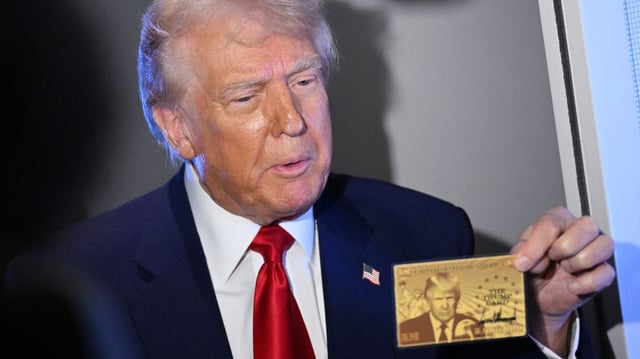 President Trump shows reporters on Air Force One a sample of the $5 million permanent residency "gold card." Photo: Mandel Ngan/AFP via Getty Images