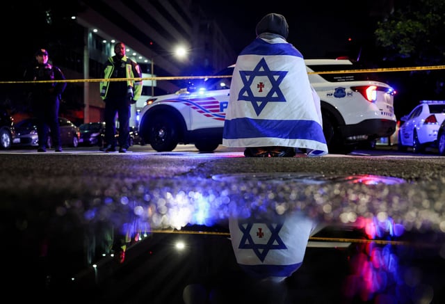 Devant le Musée juif de Washington, un homme se recouvre du drapeau israélien après l’attaque du 21 mai 2025.