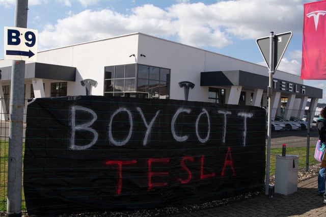 The banner of boycott is seen in front of the Tesla storefront as a dozen people take part in a worldwide boycott action against Tesla in Mulheim-Karlich, Germany, on March 29, 2025. (Photo by Ying Tang/NurPhoto via Getty Images)