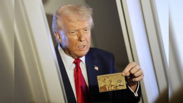 President Donald Trump holds up the $5 million gold card as he speaks to reporte...
