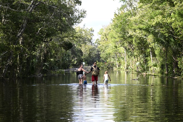 FILE - Dustin Holmes, second from right, holds hands with his girlfriend, Hailey Morgan, while returning to their flooded home with her children Aria Skye Hall, 7, right, and Kyle Ross, 4, in the aftermath of Hurricane Helene, Sept. 27, 2024, in Crystal River, Fla. (AP Photo/Phelan M. Ebenhack, File)