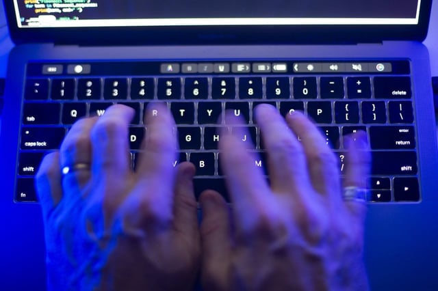 A man uses a computer keyboard in Toronto, Monday, Oct. 9, 2023 in this photo illustration. 