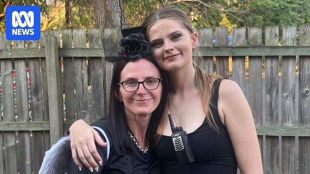 A woman with a flower fascinator hugging her taller daugher
