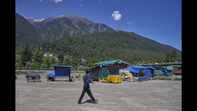A man walks past closed roadside stalls in Pahalgam on Thurssday. (AP)