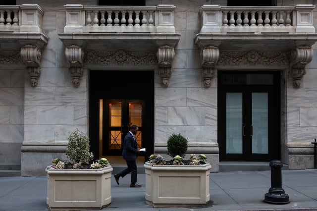A man walks outside the New York Stock Exchange (NYSE) building on Tuesday following Monday’s broad sell off in New York City, U.S., March 11, 2025. REUTERS/Shannon Stapleton/File Photo