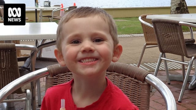 William Tyrrell in red shirt, sitting in chair with drink