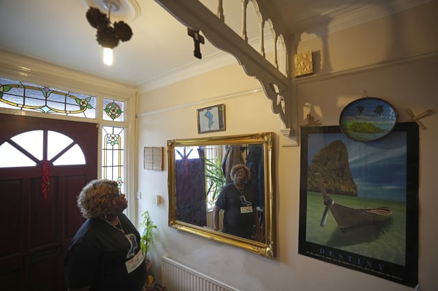 Chagossian Bernadette Dugasse looks at a Chagos Islands map during an interview with The Associated Press, at her home in London, Tuesday, March 25, 2025. (AP Photo/Kin Cheung)