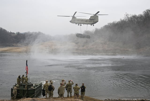 A US Army CH-47 Chinook helicopter carries a boat during a joint river-crossing exercise between South Korea and the US as part of the Freedom Shield 25 training in Yeoncheon on March 20, 2025.
