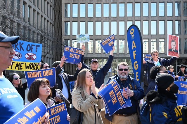 Protesters hold signs in solidarity with the American Federation of Government Employees of District 14 at a rally in support of federal workers at the Office of Personnel Management in Washington, DC, March 4, 2025. Since his inauguration, US President Donald Trump has moved to unilaterally dismantle federal agencies and fired thousands of government workers. (Photo by ALEX WROBLEWSKI/AFP via Getty Images)