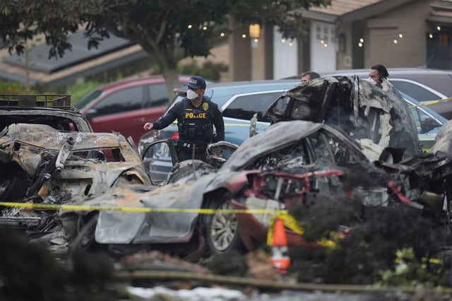 Authorities work the scene where a small plane crashed into a San Diego neighborhood early Thursday.