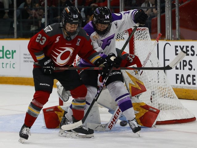 Jocelyne Larocque of the Ottawa Charge, left, tries to get the puck away from Dominique Petrie  of the Minnesota Frost during the second period of Game 2 of the PWHL final in Ottawa on Thursday.