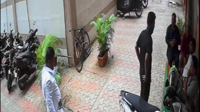 The accused (standing, dressed in black) was captured on a CCTV camera installed in the complainant’s office