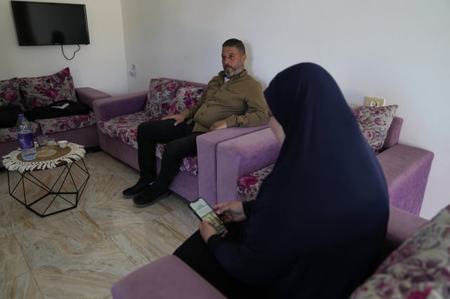 Palestinian Mohammad Amer and his wife, Iman, sit in an apartment, April 29, 2025, in the West Bank town of Zababdeh, where they fled when the Jenin refugee camp was raided by the Israeli army. Iman Amer says she was used as a human shield by Israeli soldiers there. (AP Photo/Nasser Nasser)