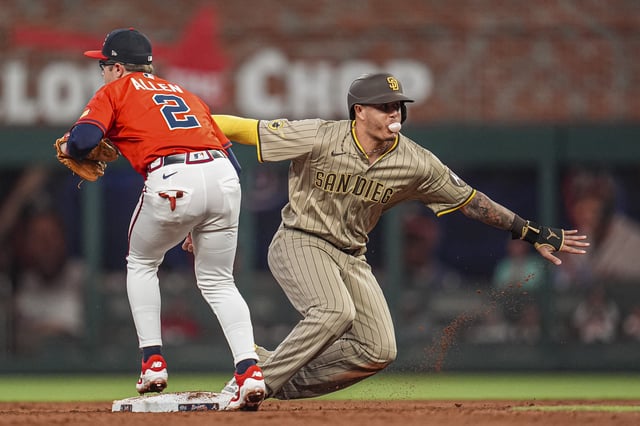 May 23, 2025; Cumberland, Georgia, USA; San Diego Padres third baseman Manny Machado (13) reacts after being tagged out stealing by Atlanta Braves shortstop Nick Allen (2) during the sixth inning at Truist Park. Mandatory Credit: Dale Zanine-Imagn Images