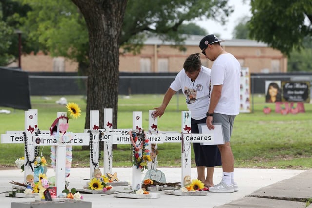 Dora Mendoza and Angel Garza, stepfather and grandmother of Robb Elementary School massacre victim Amerie Jo Garza, visit a memorial after visiting the site of the Uvalde school massacre in 2023.