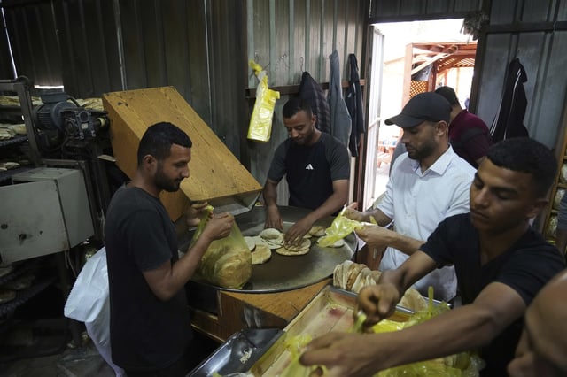 Palestinians bake bread after the World Food Program was able to bring in flour for the first time in over a month as Israel allowed some aid to enter the Gaza Strip, in Deir al-Balah, Gaza Strip, Thursday, May 22, 2025. (AP Photo/Abdel Kareem Hana)