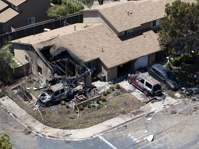 Debris covers the ground after a small plane crashed into a San Diego neighborhood, setting homes and cars on fire and forcing evacuations early Thursday, May 22, 2025. (AP Photo/William Liang)