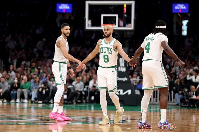 BOSTON, MASSACHUSETTS - APRIL 20: Derrick White #9 of the Boston Celtics shakes hands with Jayson Tatum #0 and Jrue Holiday #4 in Game One of the Eastern Conference First Round NBA Playoffs against the Orlando Magic at TD Garden on April 20, 2025 in Boston, Massachusetts.
