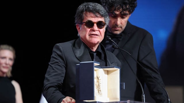 El director, guionista y productor iraní Jafar Panahi celebra en el escenario tras ganar la Palma de Oro por la película "Un simple accidente".