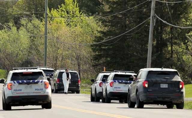  A file photo from May 11, 2023, shows police vehicles parked outside Alain Bellefeuille’s home on Laval Street in Bourget during the investigation of the shootings that had occurred there earlier that day.