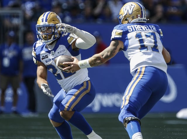 Blue Bombers quarterback Chris Streveler (17) hands off to DaMarcus Fields (22) during first-half CFL action against the Saskatchewan Roughriders in Winnipeg on Saturday, May 24, 2025. THE CANADIAN PRESS/John Woods