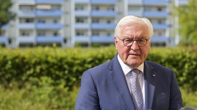 Frank-Walter Steinmeier spricht in Delitzsch vor der Kulisse eines DDR-Neubaublocks. 