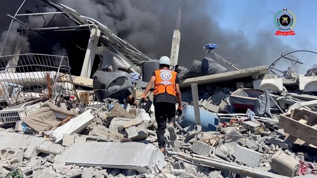 A rescuer walks over rubble to assess damage and look for survivors, in Khan Younis, Gaza, May 23, 2025, in this screengrab taken from video.   Palestinian Civil Defence/Handout via REUTERS    THIS IMAGE HAS BEEN SUPPLIED BY A THIRD PARTY. NO RESALES. NO ARCHIVES. MANDATORY CREDIT. WATERMARK FROM SOURCE