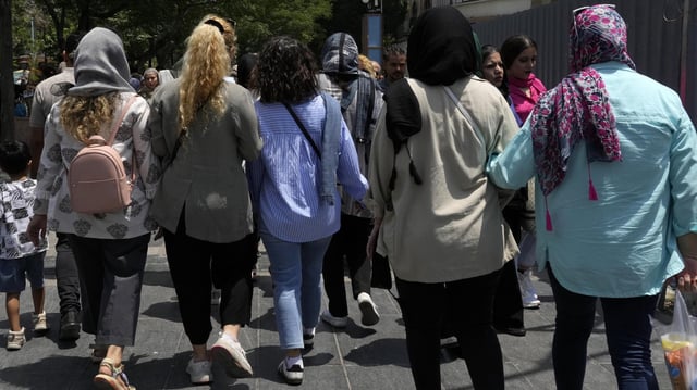 Iranische Frauen gehen über einen Basar in Teheran - teils mit, teils ohne Kopftuch. 