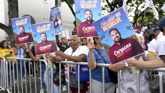 People hold up signs in support of Nicolas Maduro, son of Venezuelan president Nicolas Maduro.