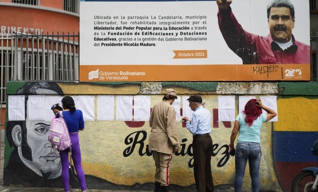 Voters look at the rolls at a polling station during legislative and local elections in Caracas, Venezuela.