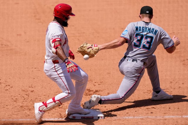 Angels’ Luis Rengifo, left, is safe at first for a single as Miami Marlins first baseman Eric Wagaman misses the throw during the fifth inning of a baseball game Sunday, May 25, 2025, in Anaheim, Calif. (AP Photo/Mark J. Terrill)