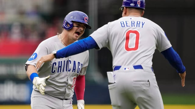 Reese McGuire (20) and third base coach Quintin Berry (0) of the Chicago Cubs celebrate after McGuire hit a home run in the second inning against the Cincinnati Reds at Great American Ball Park on Sunday, May 25, 2025, in Cincinnati. (Dylan Buell/Getty Images/TNS)