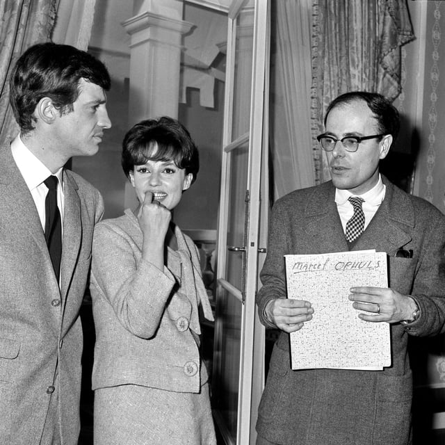 L’acteur français Jean-Paul Belmondo, l’actrice Jeanne Moreau et le réalisateur français Marcel Ophüls lors d’un cocktail à Paris.