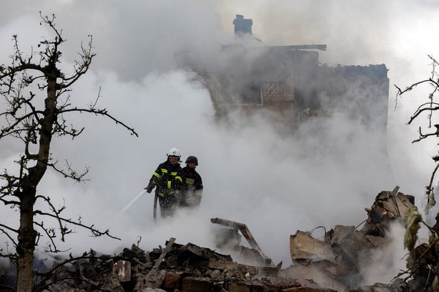 Emergency workers extinguish fire in the debris of a private house that was destroyed in a Russian rocket strike, amid Russia's attack on Ukraine, in Markhalivka, Kyiv region, Ukraine, May 25, 2025. REUTERS/Thomas Peter