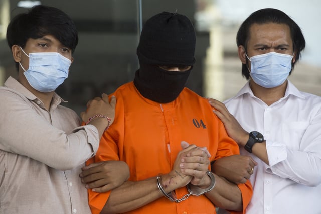 An Australian man arrested for allegedly smuggling cocaine stands escorted during a news conference at the police headquarters in Bali, Indonesia, Monday, May 26, 2025. (AP Photo/Firdia Lisnawati)