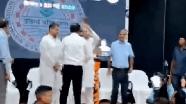 Bihar CM Nitish Kumar keeps flower pot on a person's head