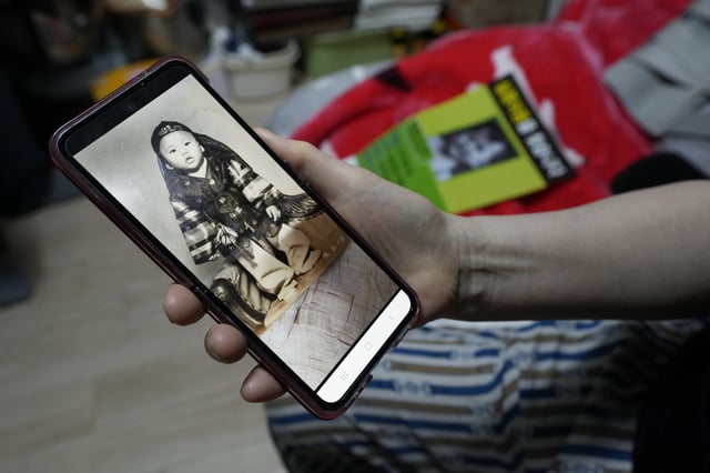 FILE - Choi Young-ja holds a smartphone displaying a photo of her son, who went missing in 1975, as she sits in her motel room in Seoul, South Korea, Tuesday, March 5, 2024. (AP Photo/Ahn Young-joon, File)