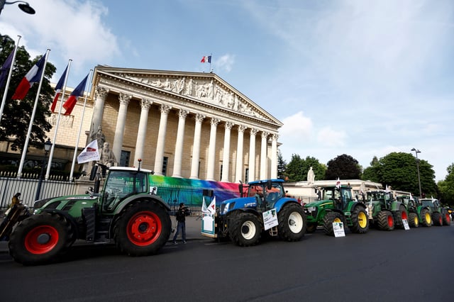 Tractors are parked in front of the French parliament, the Assemblee Nationale, as French farmers gather for a protest to call on lawmakers to adopt a bill that would loosen restrictions on pesticide and water use in farming, in Paris, France May 26, 2025. REUTERS/Abdul Saboor
