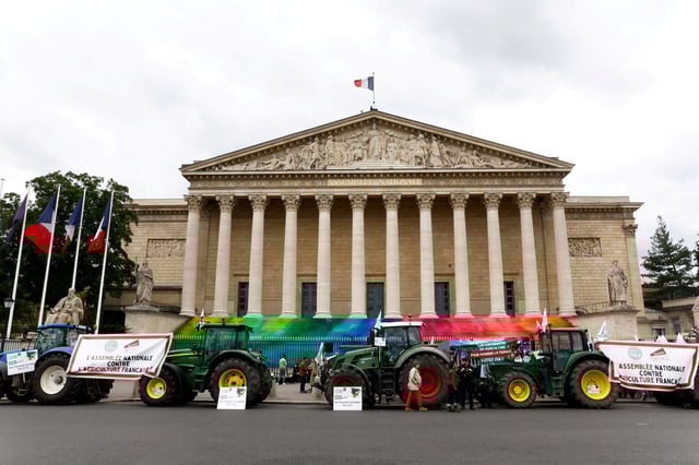 Tractors are parked in front of the French parliament, the Assemblee Nationale, as French farmers gather for a protest to call on lawmakers to adopt a bill that would loosen restrictions on pesticide and water use in farming, in Paris, France May 26, 2025. REUTERS/Abdul Saboor
